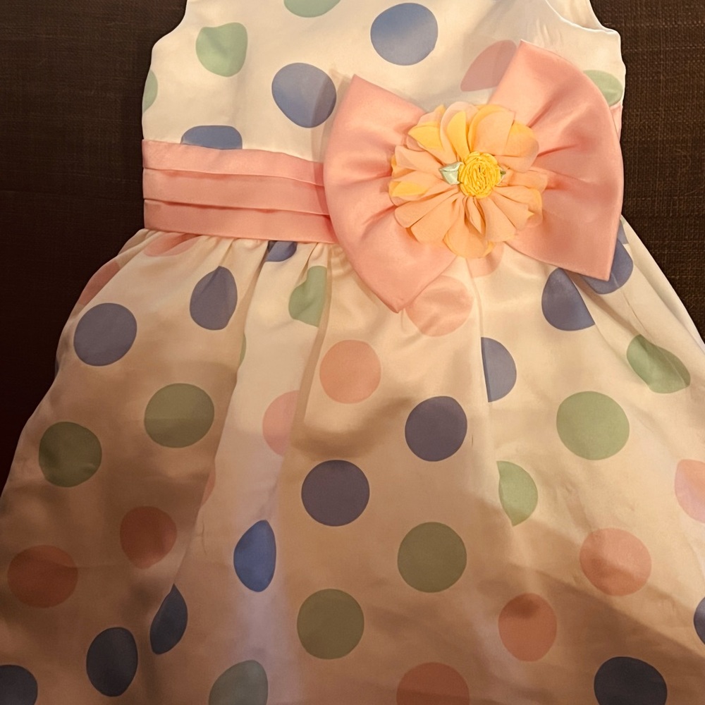Beautiful white pokadots with pink bow in front. fairly worn